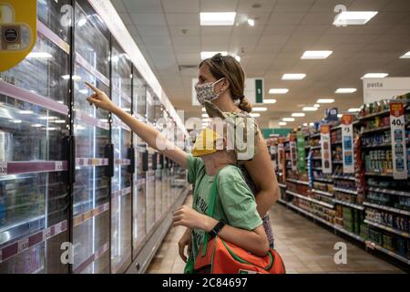 Einkaufen in der Familie in Morrisons UK Supermarkt tragen schützende Gesichtsmaschen gegen die Ausbreitung der Infektion von Coronavirus, London, England Großbritannien zu schützen Stockfoto