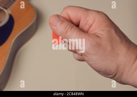 Mann zeigen, wie man richtig halten eine Gitarre Pick Stockfoto
