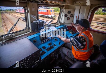 16. Juli 2020, Mecklenburg-Vorpommern, Mukran: Eine 140 gebaute Elektrolok der Baureihe 1972 wird nach der Generalinspektion in der Reparaturwerkstatt der Baltic Port Services GmbH (BPS) von Werkstattleiter Jens Wolters bei einem Testlauf über das Schienennetz der Hafenbahn gefahren. In der 1986 von der Deutschen Reichsbahn eröffneten Werkstatt wurden Schienenfahrzeuge, die von der Eisenbahnfähre kommen, von der 1,520 Millimeter breiten russischen Breitspur auf die im übrigen Europa übliche Standardspur umgemessen. Die Werkstatt, die 2014 von der heutigen Firma Enon mit Sitz in Putlit übernommen wurde Stockfoto
