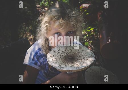 Portrait von Mädchen mit großen Sonnenschirm Pilz in der Hand Stockfoto