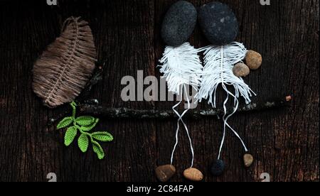 Nettes Konzept mit Witz für die Liebe Konzept Hintergrund, Paar als Skelett aus Macrame sitzen auf Ast des Baumes, Kopf aus Kieselstein so Kunst, glücklich verlieben Stockfoto