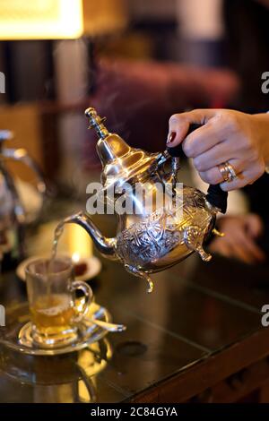 Tee in Tee Tasse auf Holztisch gießen Stockfoto