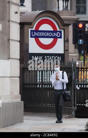 London, Großbritannien, 21. Juli 2020: Ein Mann in einer Gesichtsmaske reibt sich Handdesinfektionsmittel auf seine Hände, als er die U-Bahn an der Bank Station verlässt. Obwohl Premierminister Boris Johnson die Menschen zur Rückkehr an die Arbeit drängt, ist die City of London fast verlassen. Anna Watson/Alamy Live News Stockfoto