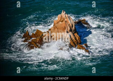 Marokko, Tanger: Felsen und Wellen am Fuße des Leuchtturms von Cape Spartel, Vorgebirge entlang der marokkanischen Küste am südlichen Eingang Stockfoto