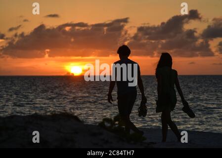 Kuba, Pinar del Rio Provinz: Paar zu Fuß auf dem feinen Sandstrand von Cayo Levisa bei Sonnenuntergang, in der Colorados Archipel, Golf von Mexiko, Nord coas Stockfoto