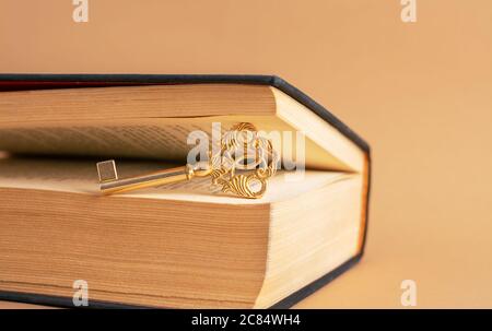 Ein alter schöner Schlüssel zwischen den Seiten des alten Buches. Stockfoto