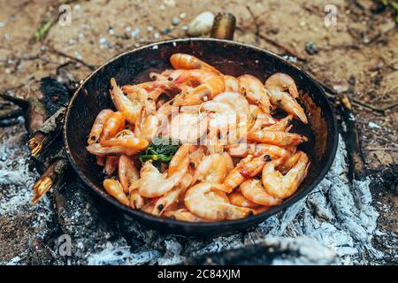 Heiße Garnelen in kochendem Öl in einer Pfanne - gegrillte Meeresfrüchte Stockfoto