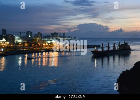 Kuba, Havanna: Nachtansicht der beleuchteten Kais der Stadt vom Schloss Morro. Frachtschiff in die Bucht Stockfoto