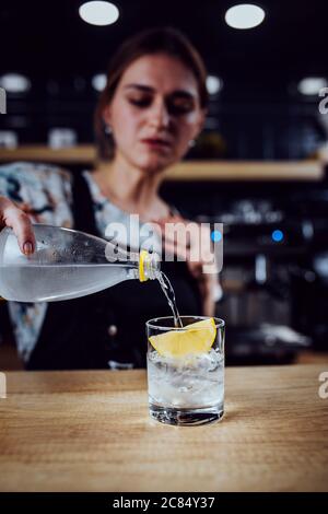 Barista Mädchen bereitet eine erfrischende Sommer-Version von Eis und Sirup Kaffee - ein unkonventionelles Rezept Stockfoto