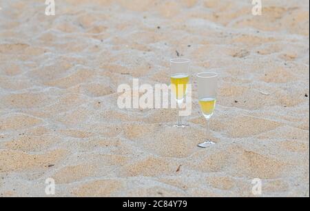 Zwei Sektgläser, die im Sand an einem Meeresstrand in Amagansett, NY, sitzen Stockfoto