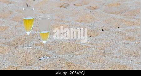Zwei Sektgläser, die im Sand an einem Meeresstrand in Amagansett, NY, sitzen Stockfoto