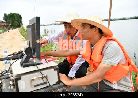 (200721) -- JIUJIANG, 21. Juli 2020 (Xinhua) -- Professor Deng Juzhi (L) und Dr. Zhou Feng analysieren die mit einem Radar gesammelten Daten auf dem inneren Deich des Furong Flusses in der Stadt Furongdun der Stadt Jiujiang, ostchinesische Provinz Jiangxi, 21. Juli 2020. Der innere Deich des Furong River hat ständige Rohrleitungsprobleme gesehen, weil eine große Anzahl von Ameisennestern darin war, was eine ernste Bedrohung für die Sicherheit der Anwohner darstellt. Quelle: Xinhua/Alamy Live News Stockfoto