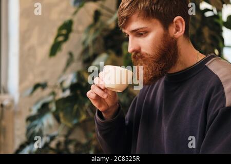 Junge attraktive bärtige Mann trinken Kaffee in Café ruhen Stockfoto