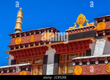 Altes buddhistisches Schlüsselkloster mit einem Dharma-Rad (Dharmachakra) auf dem Hintergrund des blauen Himmels bei Sonnenaufgang Stockfoto