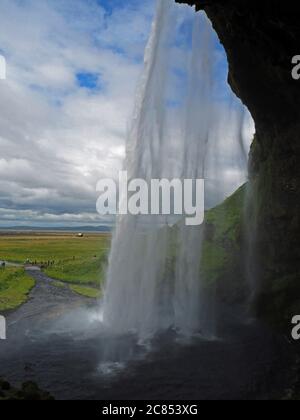 Hinter dem berühmten isländischen Wasserfall Seljalandsfoss Stockfoto