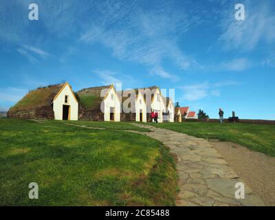 Glaumber Open Air Folk Museum traditionelle isländische Häuser mit Rasen Dach und Wände mit grünem Gras und blauen Himmel mit Besuchergruppe Stockfoto