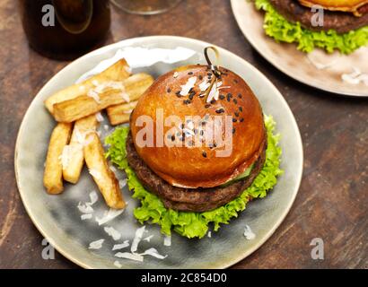 Burger und Pommes auf Holz Stockfoto
