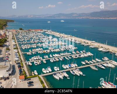 Split, Kroatien - August 23 2018: Luftbild eines Yachthafens an der Adriaküste, zeigt festgetäute Boote, klares Meer mit Bergen im Hintergrund Stockfoto