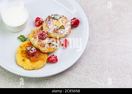 Quark Pfannkuchen mit saurer Sahne und Himbeeren Stockfoto