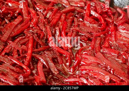 Rohe rote Rübenstreifen und Olivenöl. Rohe Rüben in Würfel geschnitten Hintergrund. Der Prozess der Röstung rote Rüben in einer Pfanne mit Olivenöl. Vollformat. Clos Stockfoto