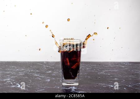 Das Getränk spritzen. Süße Flüssigkeit wird aus einem Glas ausgestreut. Stockfoto