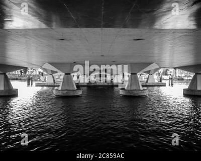Ein abstraktes Schwarz-Weiß-Bild von unter einer Brücke über die Amstel in Amsterdam Stockfoto