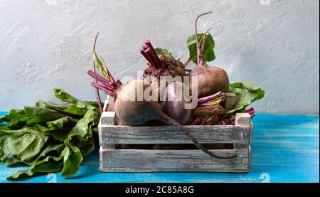 Frische Rüben in einer Holzkiste auf dem Tisch. Vitaminreiches Gemüse. Stockfoto