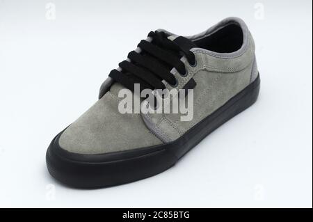 Nahaufnahme eines neuen grauen Sneakers mit schwarzer Mittelsohle Eine weiße Oberfläche Stockfoto