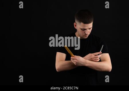 Junger Mann, brutaler, kaukasischer Hipster mit Schnurrbart. Herren Friseuse im Friseurladen. Friseurschere und -Kamm, Friseurladen. Herren Haarschnitt, Rasur. Männlich Stockfoto