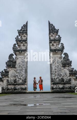 Glückliches junges Paar springen in Tempel Tore des Himmels, Wasser Reflexion. Perfektes Hochzeitskonzept. Lempuyang Luhur Tempel in Bali, Indonesien. Asien Stockfoto