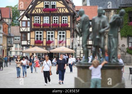 Quedlinburg, Deutschland. Juli 2020. Auf dem Marktplatz in Quedlinburg spazieren die Menschen. Die Münzenberg-Musiker, eine aus vier Figuren bestehende Bronzeskulptur des Quedlinburger Künstlers Wolfgang Dreysse, sind auf dem Marktplatz in der Altstadt von Quedlinburg zu sehen. Quelle: Matthias Bein/dpa-Zentralbild/ZB/dpa/Alamy Live News Stockfoto