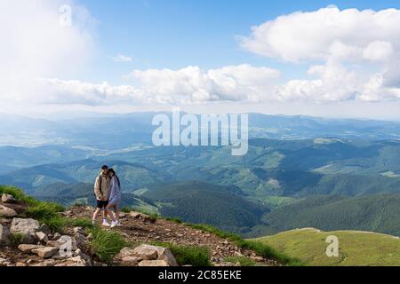 Junge glückliche Paar auf dem Hügel und genießen Sie die Aussicht auf die Berge Stockfoto