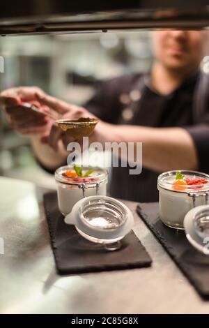 Himbeer Dessert, Käsekuchen, Kleinigkeit, Maus in einem Glas auf einem hölzernen Hintergrund. Stockfoto