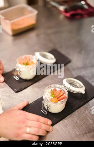 Himbeer Dessert, Käsekuchen, Kleinigkeit, Maus in einem Glas auf einem hölzernen Hintergrund. Stockfoto