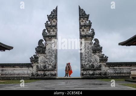 Glückliches junges Paar springen in Tempel Tore des Himmels, Wasser Reflexion. Perfektes Hochzeitskonzept. Lempuyang Luhur Tempel in Bali, Indonesien. Asien Stockfoto