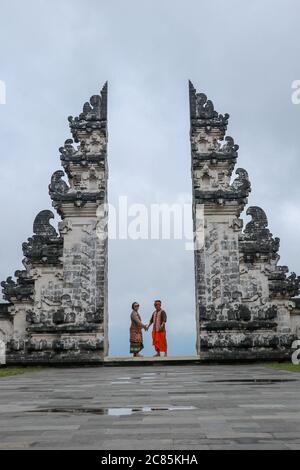 Glückliches junges Paar springen in Tempel Tore des Himmels, Wasser Reflexion. Perfektes Hochzeitskonzept. Lempuyang Luhur Tempel in Bali, Indonesien. Asien Stockfoto