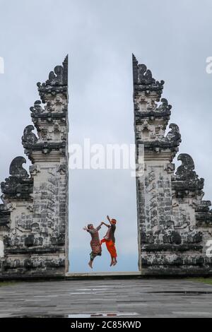 Glückliches junges Paar, das in die Tempeltore des Himmels springt. Perfektes Hochzeitskonzept. Lempuyang Luhur Tempel in Bali, Indonesien Stockfoto