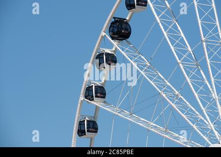 NATIONAL HARBOR, Maryland, USA – Ein großes Riesenrad steht am Ufer des National Harbor in Maryland, am Ufer des Potomac River, direkt gegenüber von Washington DC. Das Riesenrad, eine beliebte Attraktion, bietet einen atemberaubenden Blick auf den Potomac und die Umgebung, einschließlich der Skyline von Washington DC. Stockfoto