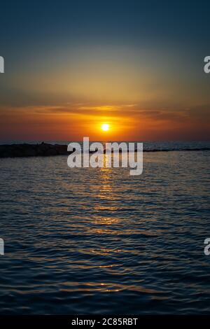 Wunderbarer Sonnenuntergang über dem Meer am Horizont. Das Ende des Tages am Meer. Helle und intensive Farben der Natur. Stockfoto