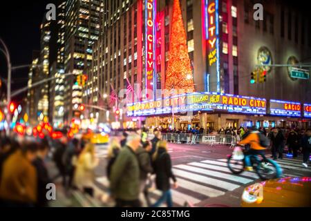 Eine Menschenmenge überquert die 6th Avenue vor der Radio City Music Hall Stockfoto