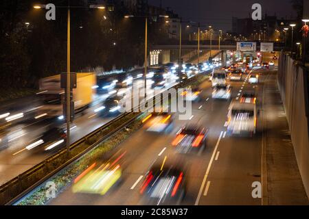 Der schnell fahrende Verkehr verläuft entlang einer deutschen Autobahn, die von der Münchner Innenstadt während der abendlichen Hauptverkehrszeit zum Flughafen führt. Stockfoto