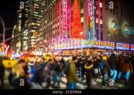 Eine Menschenmenge überquert die 6th Avenue vor der Radio City Music Hall Stockfoto