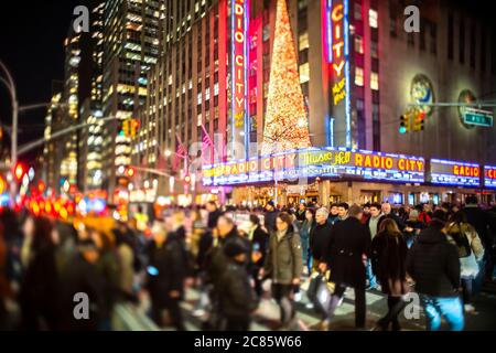 Eine Menschenmenge überquert die 6th Avenue vor der Radio City Music Hall Stockfoto