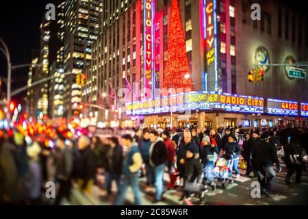 Eine Menschenmenge überquert die 6th Avenue vor der Radio City Music Hall Stockfoto