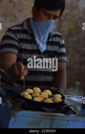 Hyderabad, Telangana, Indien. juli-20-2020: indische Street Food Maker Zubereitung süß, während das Tragen von Gesichtsmaske, leckeres Essen, Corona Pandemie Konzept Stockfoto