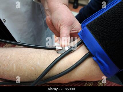 Die Hand des Sanitäters, der Blutdruck und Herzfrequenz durch Tonometer eines Patienten nimmt Stockfoto