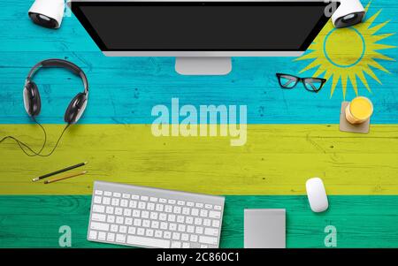 Ruanda Flagge Hintergrund mit Kopfhörer, Computer-Tastatur und Maus auf nationalen Büro Schreibtisch table.Top Ansicht mit Copy Space.Flat Lay. Stockfoto