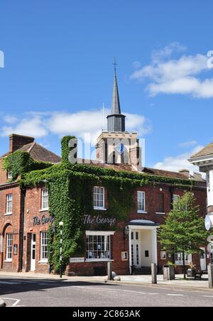 Hitchin Street, (mit 'The George' an der Ecke Church Street und der Kirche dahinter), Baldock, Hertfordshire, England, Großbritannien Stockfoto