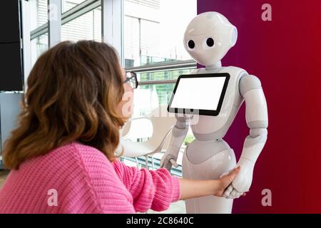 Eine Frau kommuniziert mit einem Roboter Berater Stockfoto