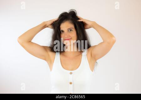 Hübsche junge Frau mit langen schwarzen Haaren macht Geste Stockfoto